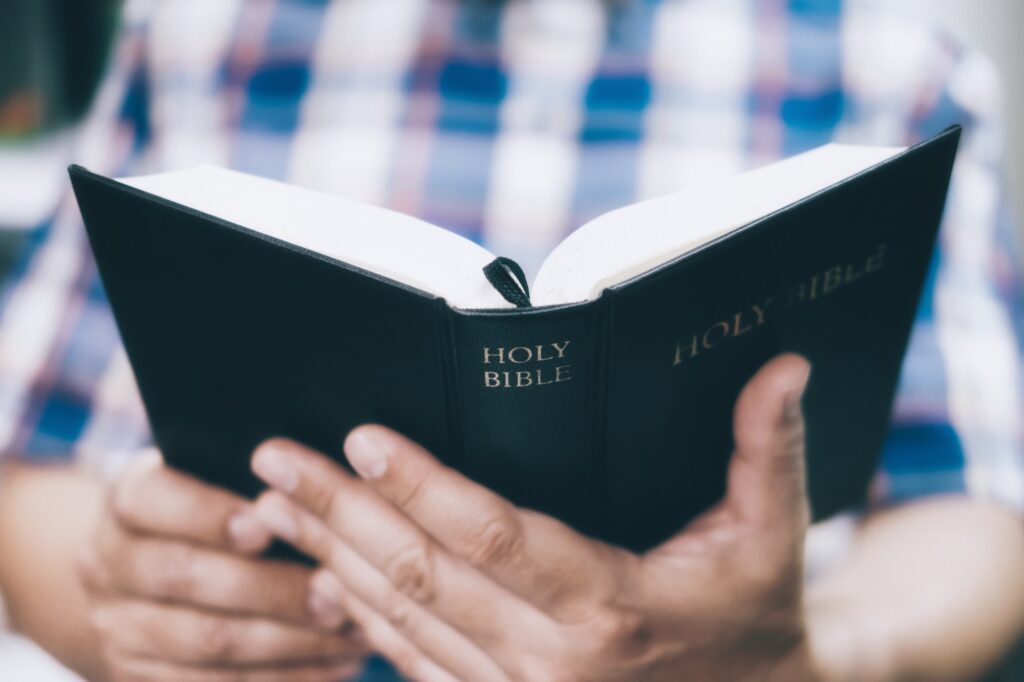 Man holding and reading the holy bible.